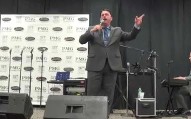 Brian Burchfield singing with his hand raised