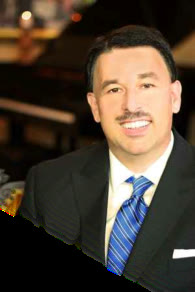 Brian Burchfield in a dark suit and blue tie